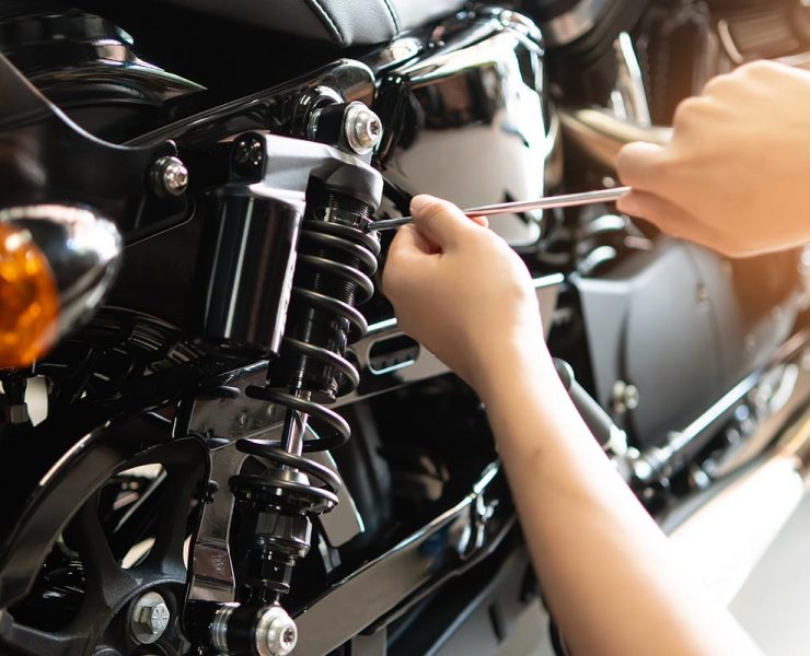 Mechanic using Tools set up suspension sag Compression and Rebound on a motorcycle in garage,maintenance motorcycle concept .selective focus